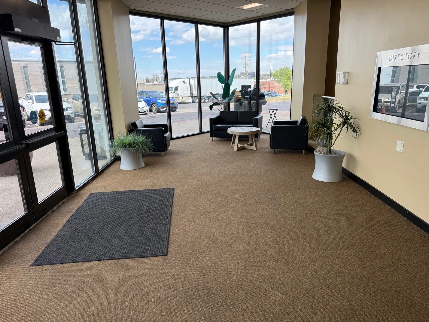 Ground-floor lobby with seating, plants, and a directory.