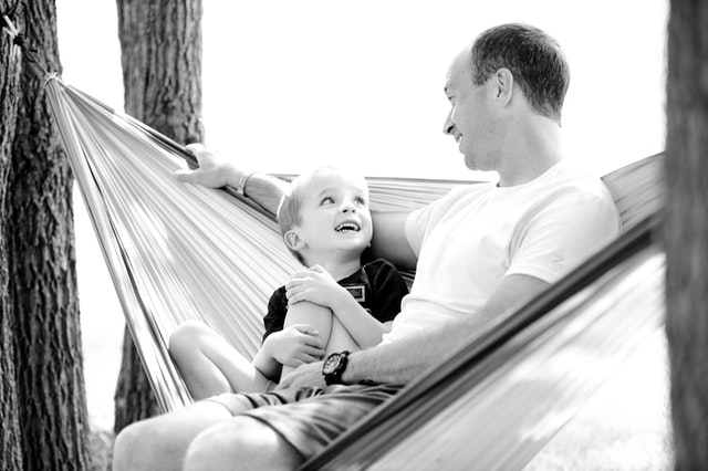 happy father and son hanging out in a hammock