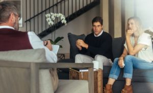 Couple is sitting on sofa and talking to the psychologist