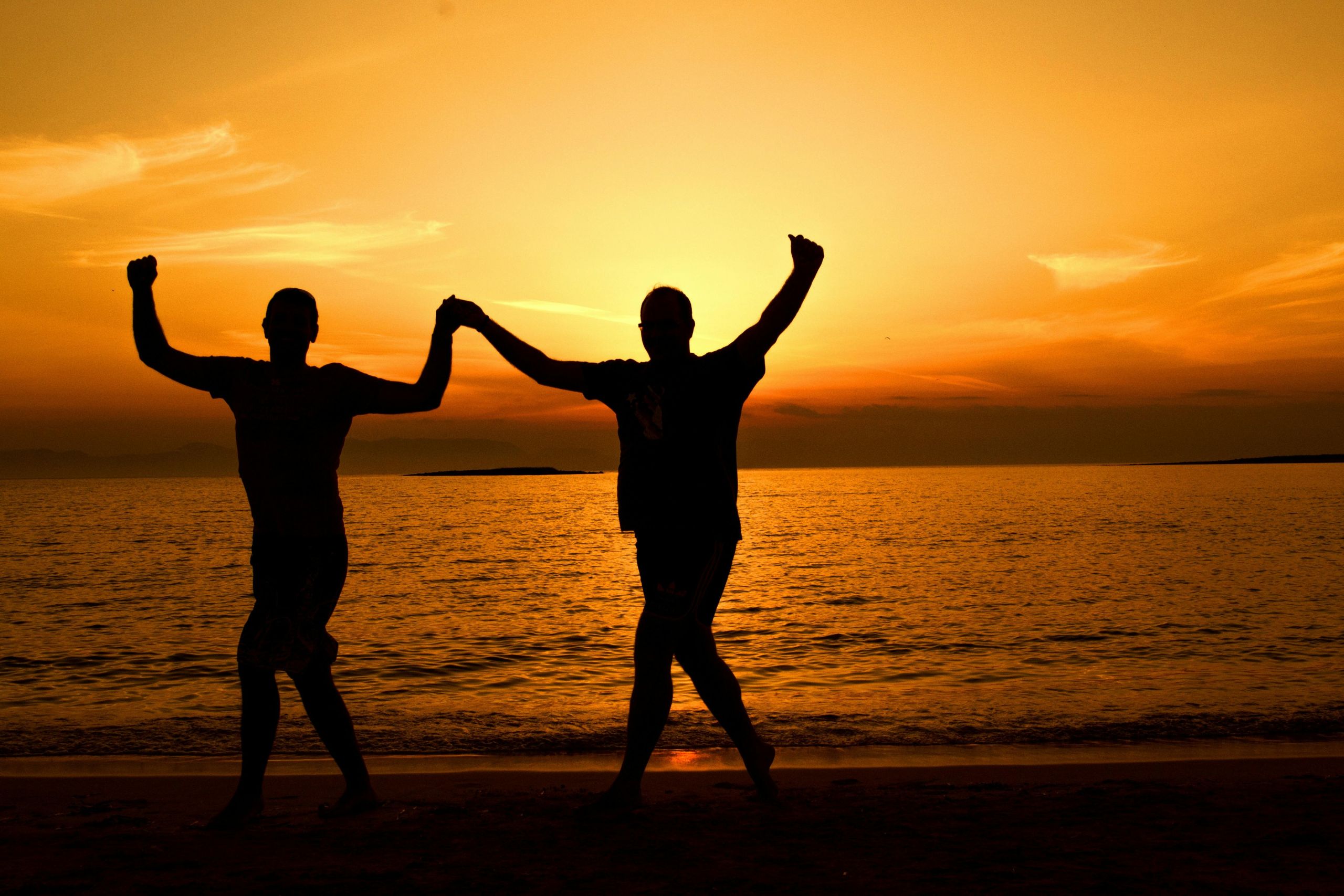 Holding hands on a beach at sunset